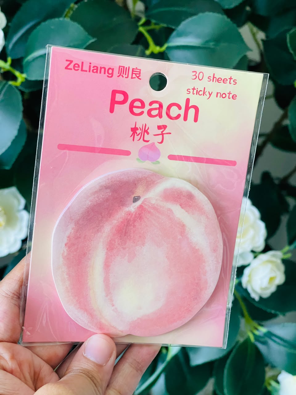 Peach sticky notes stuck on a planner page next to a pen