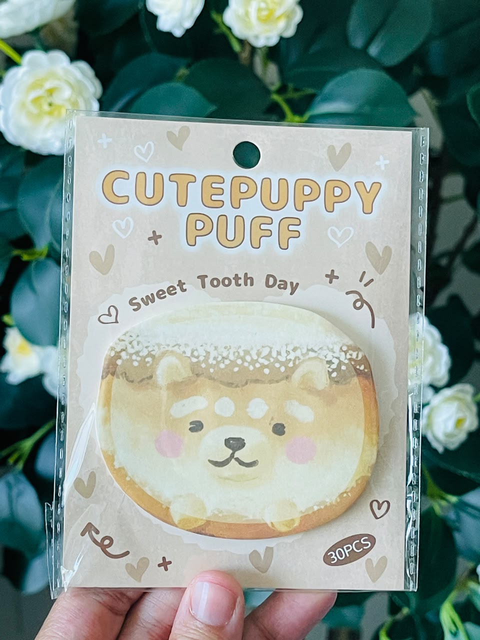 A hand holds a packaged 'CutePuppy Puff' tooth powder pouch. The packaging is beige with cute puppy illustrations and the text 'Sweet Tooth Day' and '30PCS'.