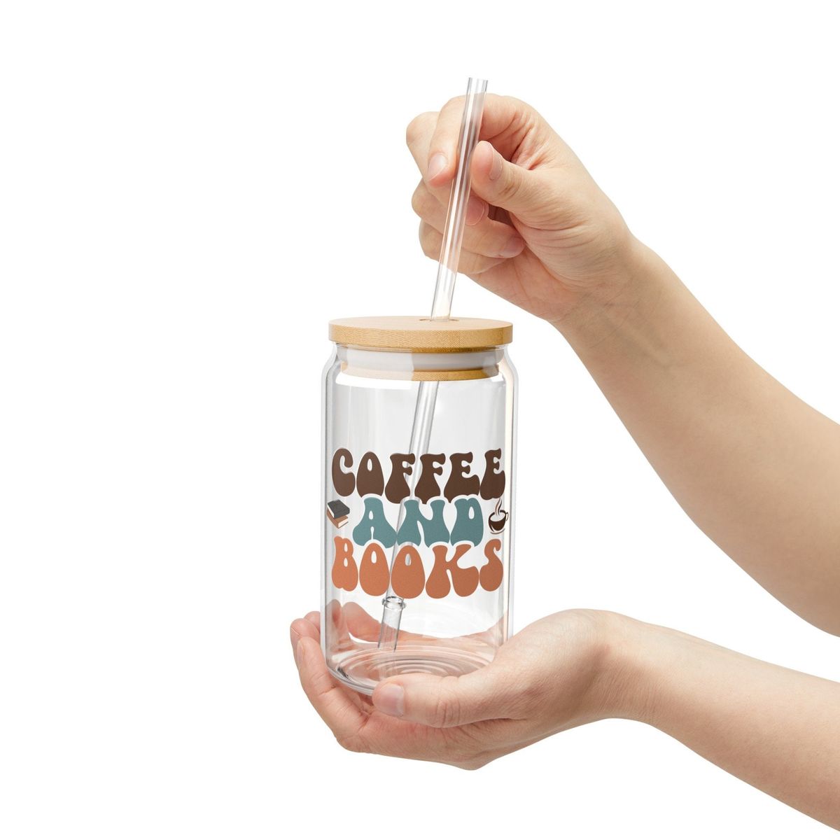 Glass tumbler with straw and wooden lid held by a hand on a white background